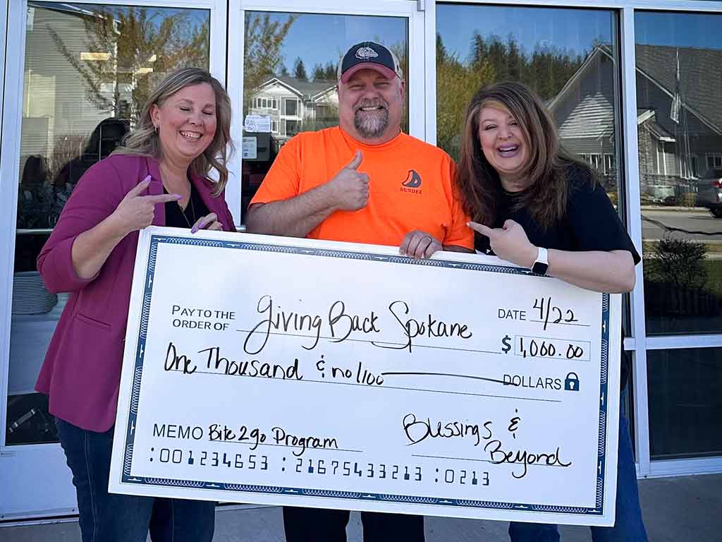 Blessings and Beyond giving a check to Giving Back Spokane